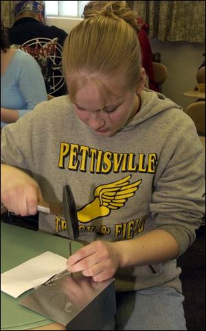 NBR  home21p  Pettisville, Ohio. Stephanie Hamilton 18, pounds indentations in tin to create tin art.    The Blade/Diane Hires  3/21/05