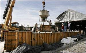 Pete Chestnut guides a bucket of concrete into place above the mold. The segment will cure for about a month. Bridge passes construction milestone