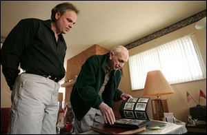 John Smith and his father, Paul, look over old photos in their home, built on the site of one lost in the tornado.