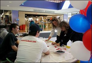 Dave Scharfeld, left, Chris Renner, Monika Winkler, and Kylee Munson look over information at the College Republicans table in the Bowling Green State University Student Union.