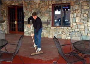 Owner Alva Caple gets the patio ready at the Durty Bird, which he said derives about two-thirds of its business from Hens fans. 