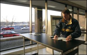 CTY taxday15p  While cars line up outside of the United States Postal Station on Superior Street in downtown Toledo, Ohio, Brad Burns, of Sylvania, inside the post office, puts the finishing touches on his tax returns on the evening of April 15, 2005. The Blade/Jetta Fraser