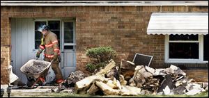 CTY fire16p 1 A fireman removes debris from the home at 3540 McCord Road Friday, 04/15/05, in Toledo, O., after a fire. The Blade/Jeremy Wadsworth