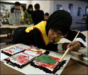 Aisha Deme, 8, of Bowling Green paints tiles that will become part of a larger mosaic for the Islamic School of Greater Toledo.