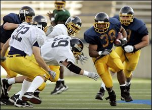 Rockets running back Trinity Dawson eludes defenders during the Blue and Gold Spring Game yesterday at the Glass Bowl.