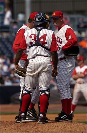 Hens pitching coach Jeff Jones, catcher Sandy Martinez and reliever Craig Dingman have a conference.