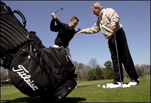Don Kotnik, right, instructs A.J. Riley at Toledo Country Club. Kotnik has been voted in as a member of six halls of fame.
