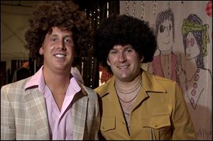  70S ARE HAIR AGAIN: Jeff Chaaf, left, and Doug Kwiatkowski take a break from tending bar at the East Toledo gala.
