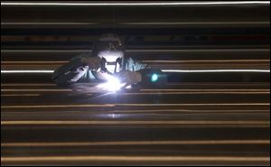 Jim Adams smooths out a weld on the stainless steel covering that will sheath the cable stays that will help hold up the I-280 bridge over the Maumee River. The pipes are being welded in sections at an off-site warehouse and will be trucked to the bridge for assembly and additional welding.