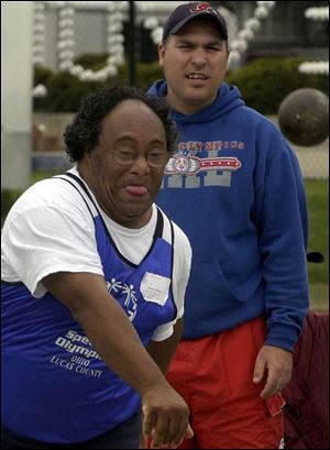 Shot putter Don Sydnor of Lucas County receives encouragement from William Ball as he competes in the Special Olympics Spring Games. 