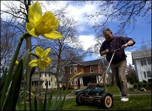 Mickey Cochrane cuts his lawn with his 1960 push mower.