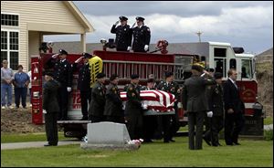 Fellow soldiers carry the casket containing Sgt. Andy
Eckert to his burial at Whitehouse Cemetery yesterday.
