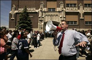 Riverside Elementary Principal Jim Gault uses a bullhorn to address worried parents and family members after a man with two guns was seen inside the school. Mr. Gault spent two hours releasing students one-by-one to family members who came to take them home.