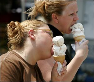 Tammy Bronowski of Genoa and Tina James of Toledo have the heat licked with a couple of ice creams at Taste of the Town.
