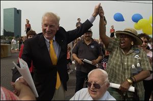 Carty Finkbeiner joins hands with supporter Lola Williams behind former Toledo Mayor Harry Kessler at The Docks after Mr. Finkbeiner announced his plans to run for mayor again.
