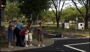 Toledo Police Officer Penny Halcomb quizzes visitors to Safe-T-City about the proper way to cross a street at an intersection. 