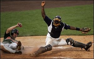 Mud Hens catcher Sandy Martinez keeps Bisons runner Jeff Liefer from reaching the plate safely.
