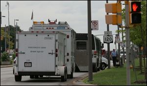 Authorities examine bus No. 914 on Cherry Street near Spielbusch Avenue after three devices with wires were found on board.