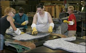 Vehicle flooring insulation is formed into the finished shape at the Janesville-Sackner factory. 