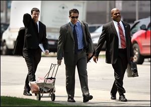 Justin Meeks, left, and Del Wright, Jr., right, of the Department
of Justice join Dean Martin of the Internal Revenue Service on
the way to a grand jury session in Toledo in the Tom Noe case.
