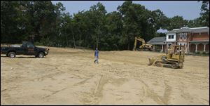 A bulldozer grades a portion of the parking lot area at the Bowling Green library branch.
