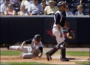 Louisville's Steve Lomasney slides home safely as Hens catcher Brandon Harper waits for the throw. The Hens clinched a playoff spot Saturday night, and it appeared yesterday's day game came a little too soon.