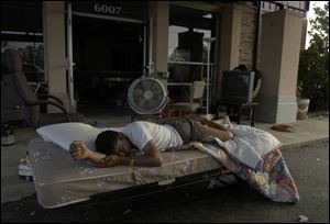 A hurricane evacuee sleeps outside an abandoned motel along U.S. 90 in Pascagoula, Miss., where aid workers and authorities are trying to deal with limited supplies of food and water.