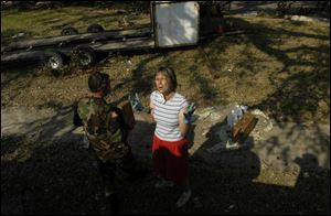 Sandy Ford asks National Guardsmen for more ice and water near her home in Pascagoula, Miss. Her home was cut off from main roads by debris and she is caring for 10 storm victims.