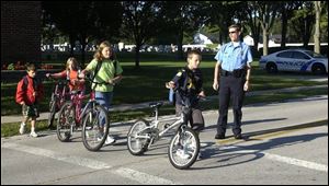 Luckey police Chief Eric Shiffler watches traffic as students cross at Luckey Elementary School. A stoplight in front of the school was damaged and, under ODOT rules, won t be replaced.
