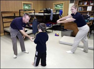 Cary Irvin, left, and Joselin Meesenburg work with Liam McGlofton in a Safe Kids course at Camp Miakonda in Sylvania Township. This is the first Warrior School in the Toledo area.
