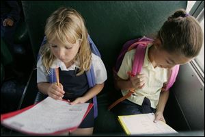 Hawkins Elementary bus riders Krystin Farmer, 2nd grade, and Taylor Burton, 4th grade, do homework on their way home.