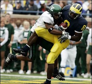 Michigan s Jason Avant, right, hauls in a touchdown pass against Eastern Michigan defender
Steven Lewis from Rogers High School.
