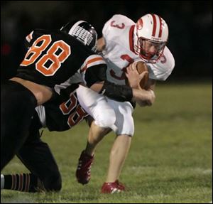 Eastwood quarterback Eric Rutherford is sacked by Otsego defenders Eric Zuhlsdorf (88) and Justin Southwick in the second quarter. Zuhlsdorf later caught
the gamewinning touchdown pass in the fifth overtime.
