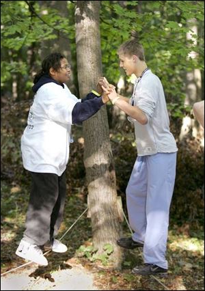 Gary Wiatt of Akron, left, and Zach Caron of Toledo work together as they navigate a rope during the children's camp on Kelleys Island.