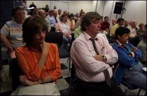 Caroline Freeman, left, and her husband, William, listen to comments made during the
public hearing on the library s controversial plan to rezone land for a parking lot.
