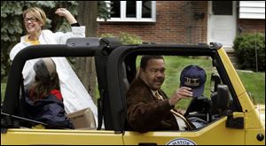Mayor Jack Ford shows his allegiance while riding in the University of Toledo
homecoming parade with wife Cynthia and daughter Jacqueline yesterday.