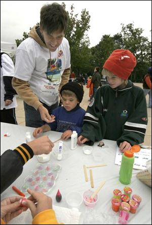 Keith Haack, left, helps children Max and Sam make an  incrediblob' ball; right, Paul Janssen displays his Legos at the Joys of Toys part of National Chemistry Week at the Toledo Zoo, sponsored by the American Chemical Society.
