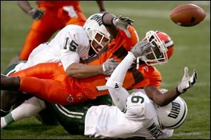 After catching a pass, Bowling Green's Charles Sharon fumbles the ball after being hit by Robert Preston (15) and Tony Ward. BGSU's Steve Sanders recovered in the end zone for a touchdown.