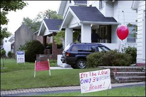 Signs remind people interested in bidding on a house near UT of city housing restrictions.