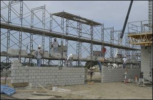 Workers lay cinder blocks on Oct. 13 as they ready the inside the building for work in winter.