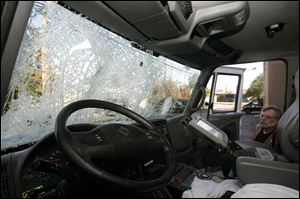 Tom Couture, Lucas County EMS support services manager, looks over a life squad vehicle that was damaged in the riot.
