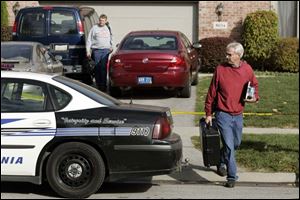 Crime scene Detective Chad Culpert, front, and police Detective Ervin Bratt leave the crime scene on Littlefield Court. Anaya
