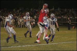 Patrick Henry's Marc Krauss hauls in a fourth-quarter touchdown for the Patriots on a seven-yard pass from Zack George despite the tackle of Elmwood defender Brian Bevelhymer.
