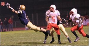 St. John s Jake Bombrys gives maximum effort in an attempt to make a reception in the second quarter against Elyria.
