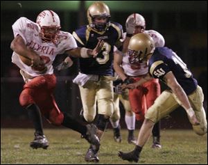 Elyria's Jaa'Rome Williams has a stiff arm ready to fend off St. John's defender Jake Bombrys last night.
