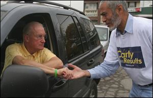 Toledo mayoral candidate Carty Finkbeiner gives some instructions to campaign worker Abdul Khan before Mr. Finkbeiner's door-to-door walk yesterday.
