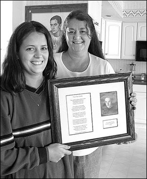 Angela Hall, left, holds a framed tribute to her late brother Billy, who died seven years ago in a traffic accident, as her mother, Leslie Hertzfeld, looks on in the family home. the blade/lisa dutton The firm's magnets can be personalized by the buyer.