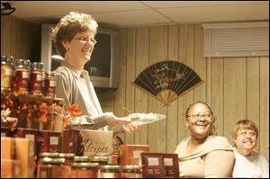 Wendy McGrady, left, hosts a Tastefully Simple party at her home in Sylvania.