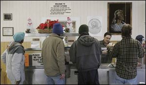 Glenn Gardner, a volunteer from Castalia, Ohio, serves meals at the Victory Temple Soup Kitchen in Sandusky.