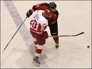 Rick Judson (20), a nine-year Storm veteran who signed a contract yesterday, battles Matt Dzieduszycki for the puck.
